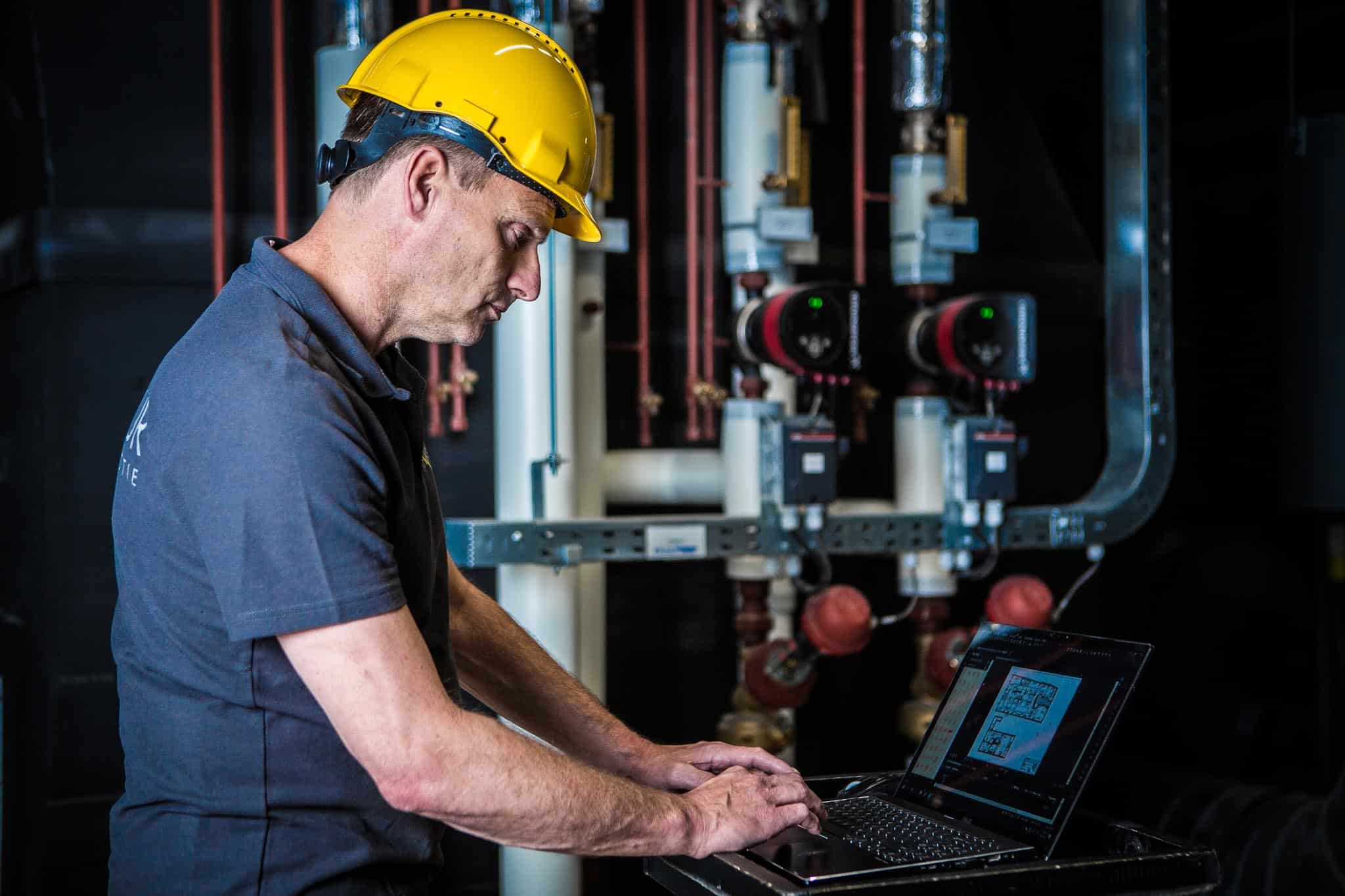 Bauarbeiter mit Laptop auf der Baustelle