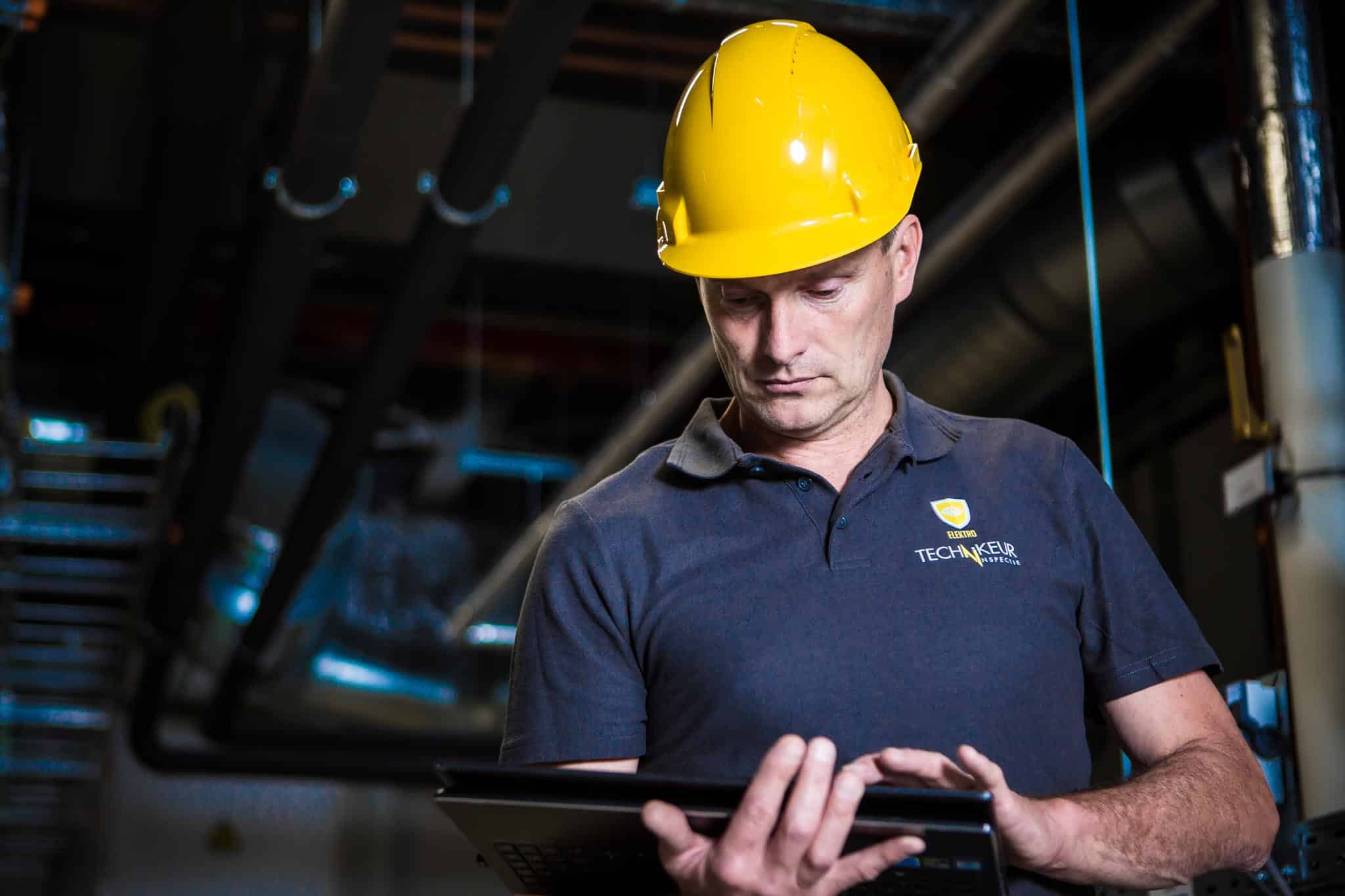 Bauarbeiter auf einer Baustelle schaut auf ein Tablet